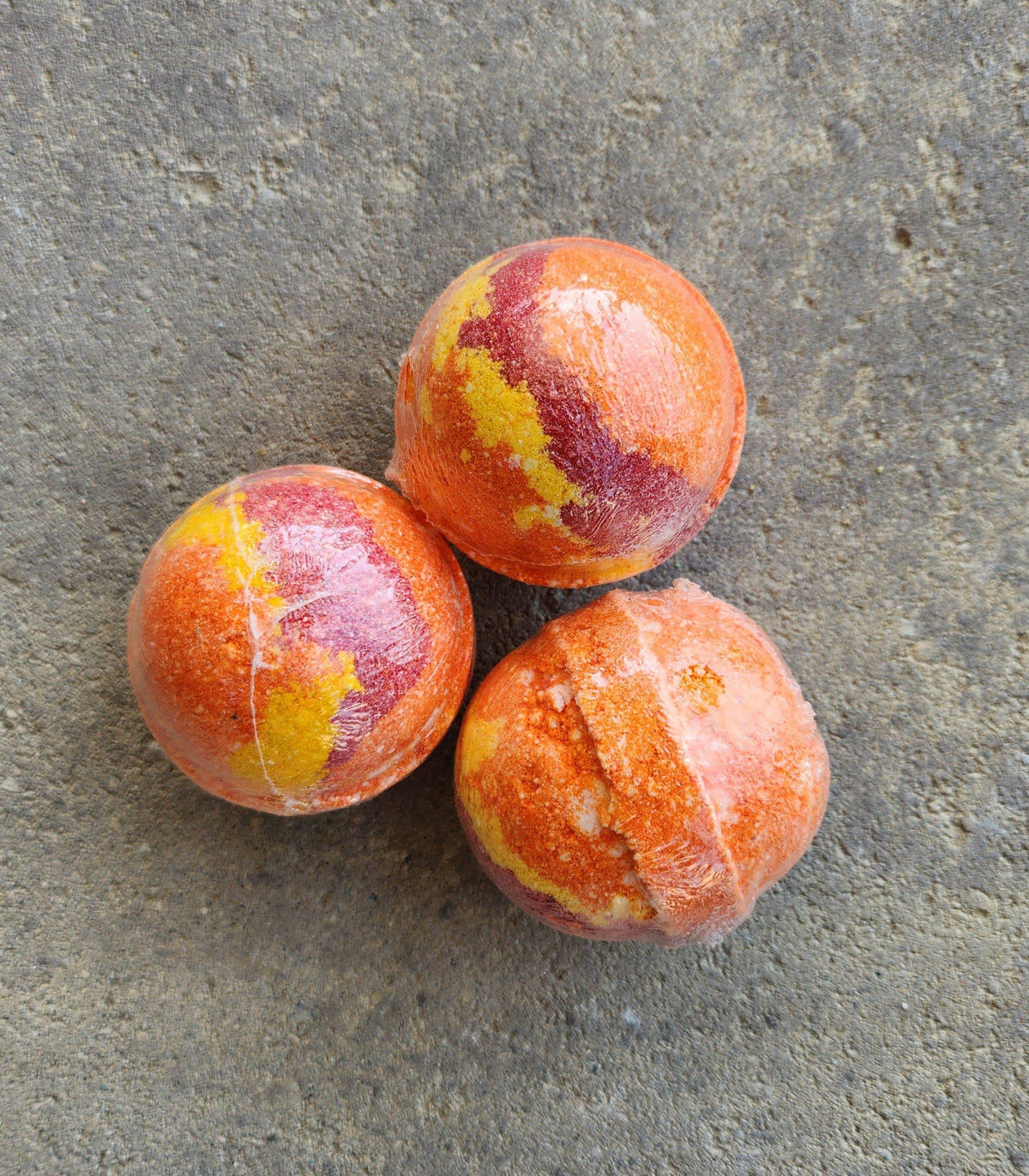 Three Herbal Island Jamaican Paradise bath bombs in a white container, showcasing colorful spherical bath products.
