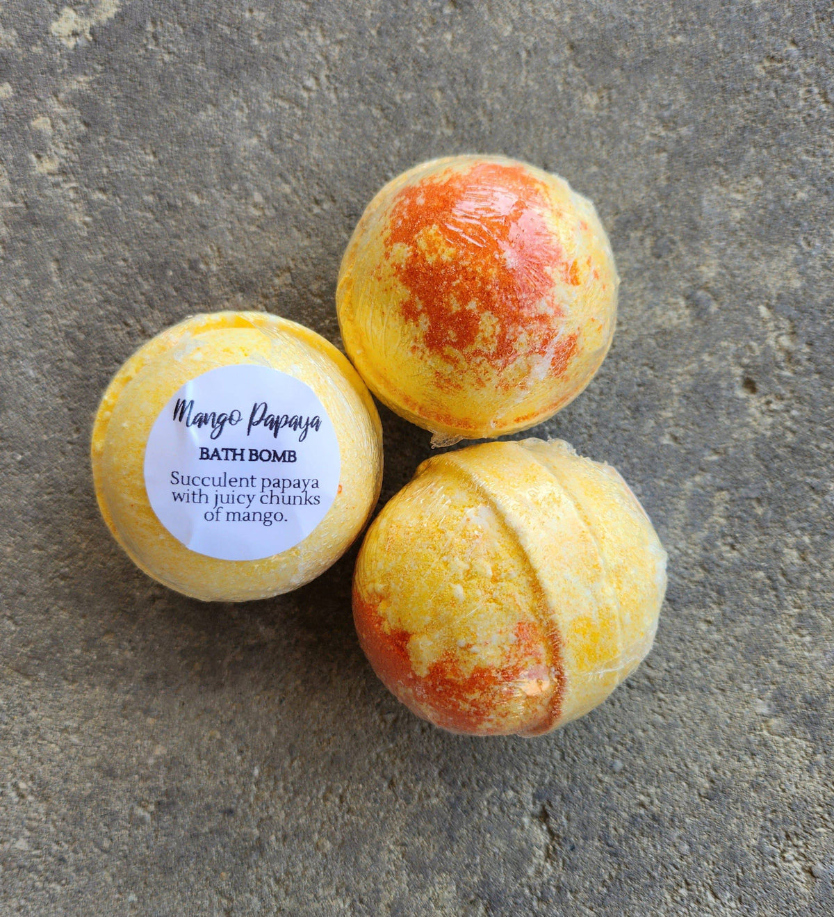 Herbal Island mango and papaya bath bombs in a 3-pack, whole bath bombs with vibrant orange and yellow colors, natural fruit scent.