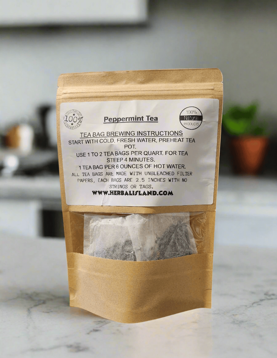 Herbal Island peppermint tea bags stacked in a clear box, ready for brewing, with fresh peppermint leaves in the background.